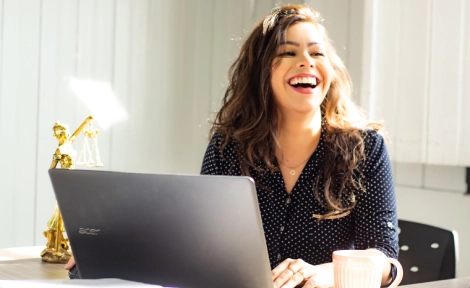 jeune femme souriante devant son ordinateur 