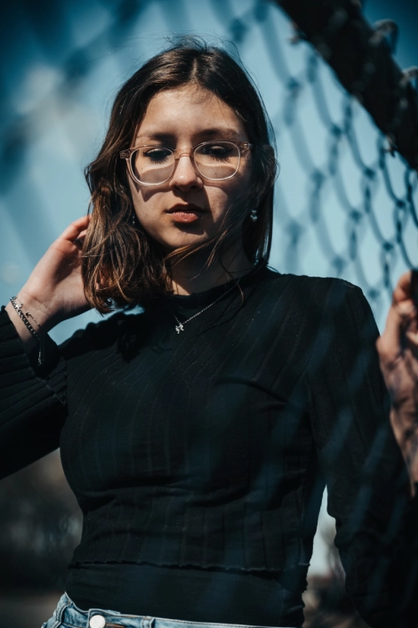 portrait d'une jeune femme à lunette avec un haut noir