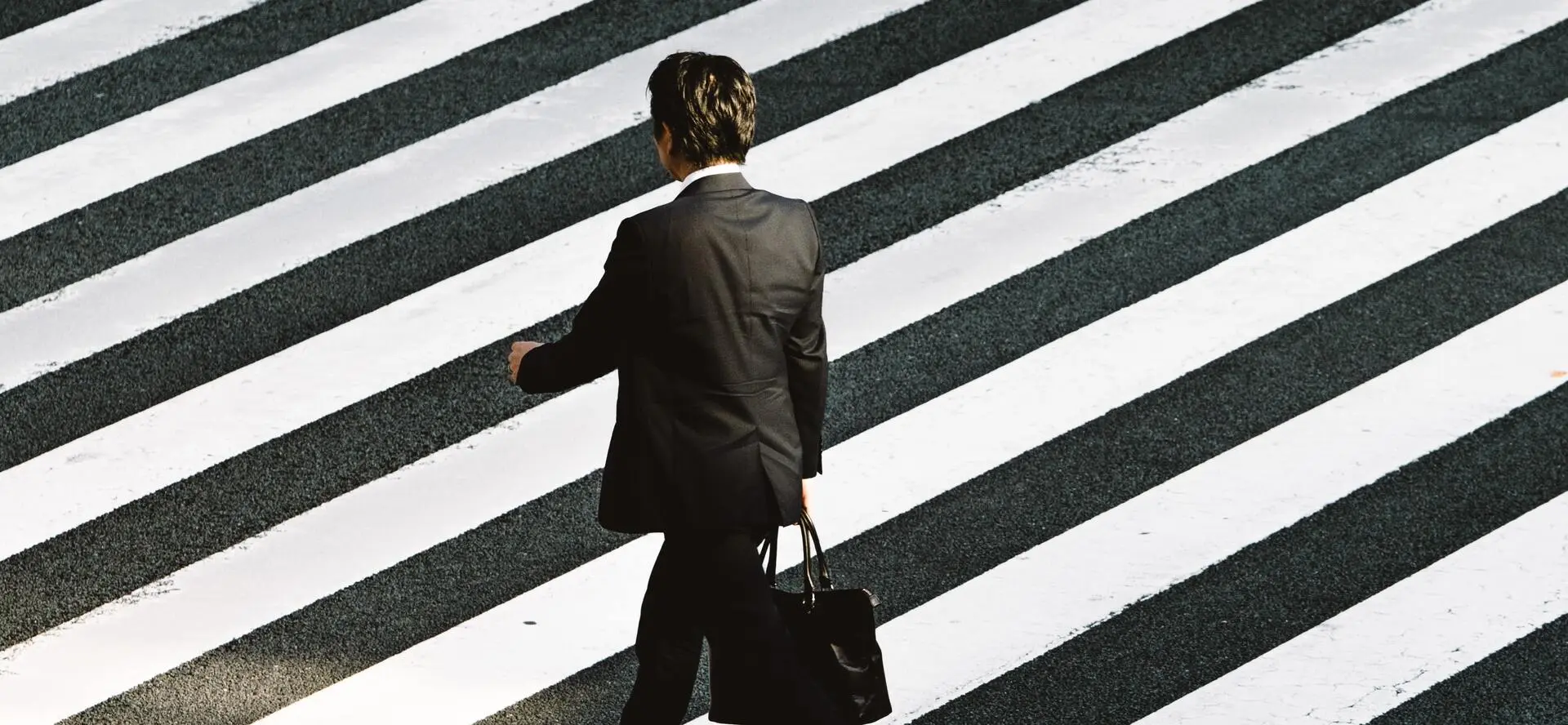 Homme en costume sur un passage piéton